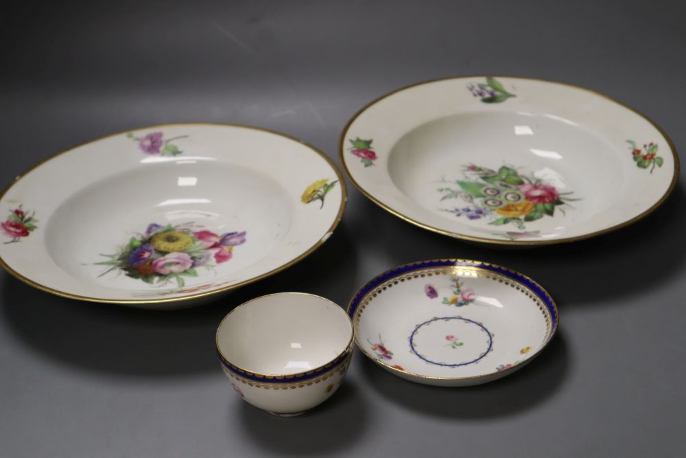 A Chelsea Derby teabowl and saucer painted in the style of Edward Withers with flowers under a blue border and a pair of soup plates